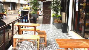 An outdoor seating area with tables and chairs, a patterned floor, and a sign reading "URBANTEL". - Urbantel Hotel (Lucena)