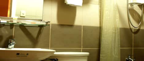 Un baño con inodoro, lavabo y ducha.