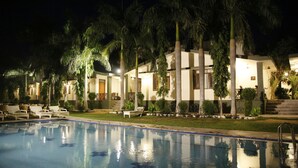 A poolside area with lounge chairs and a swimming pool. - Hotel Ranthambore Regency (Sawai Madhopur)