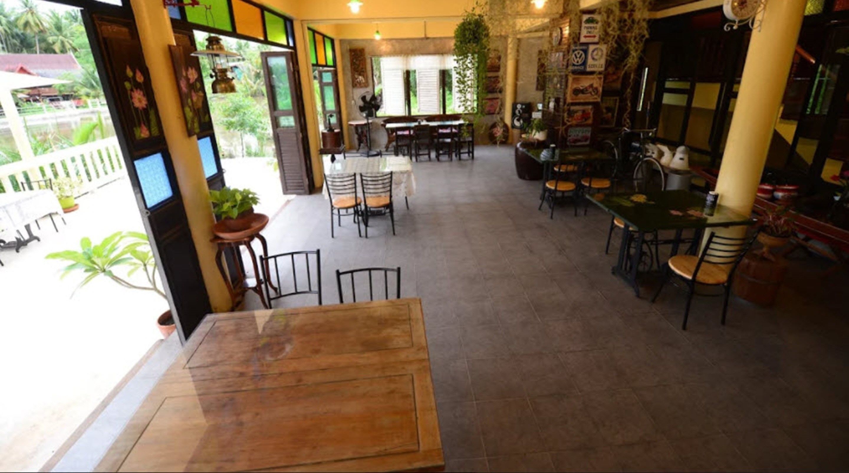 A restaurant with outdoor seating, a piano, and various plants.