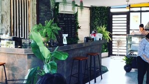 A modern cafe with a bar area, seating, and a menu board. - River Jam Amphawa (Amphawa)