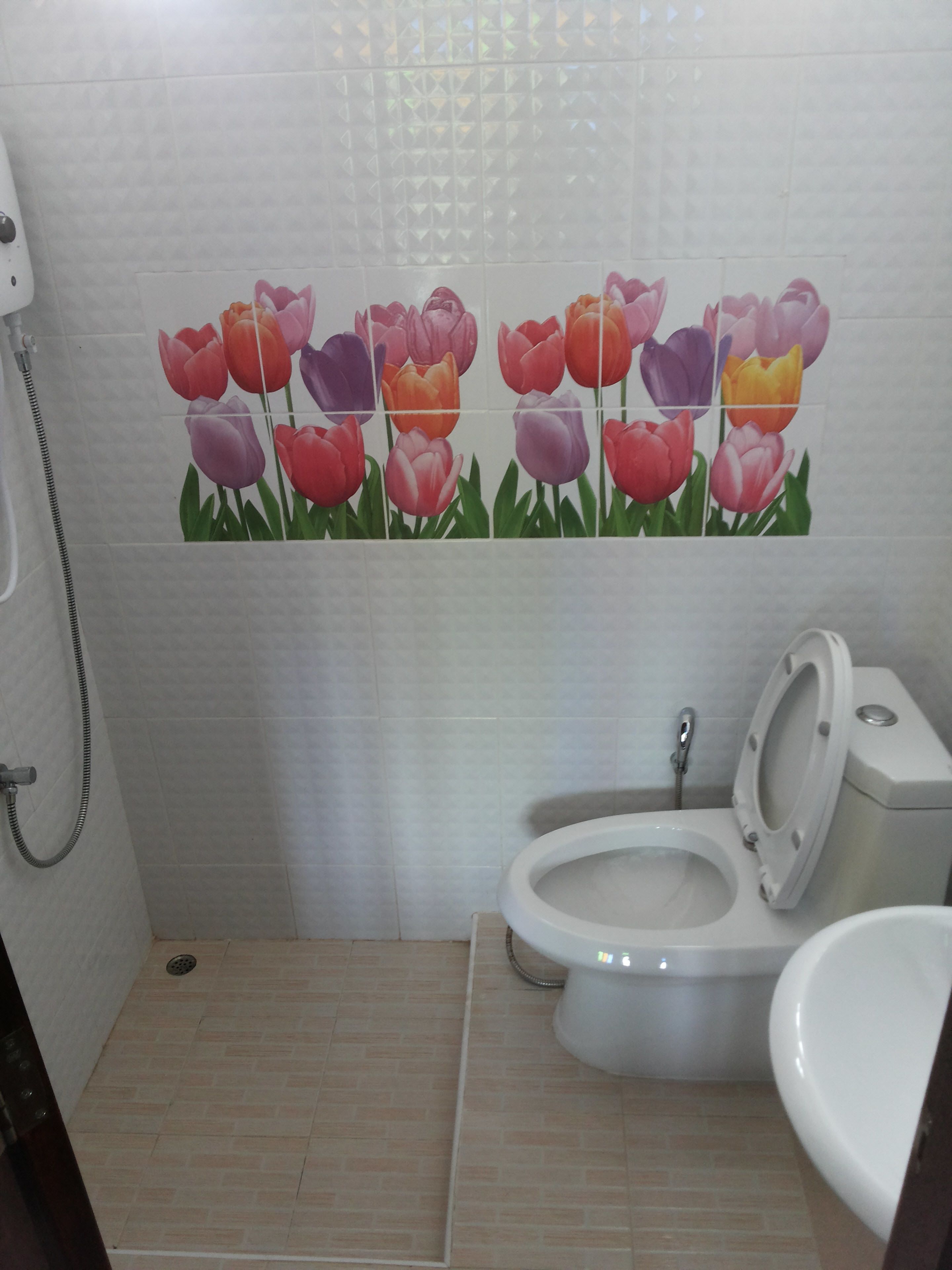 A bathroom with a toilet, bidet, and a shower area.