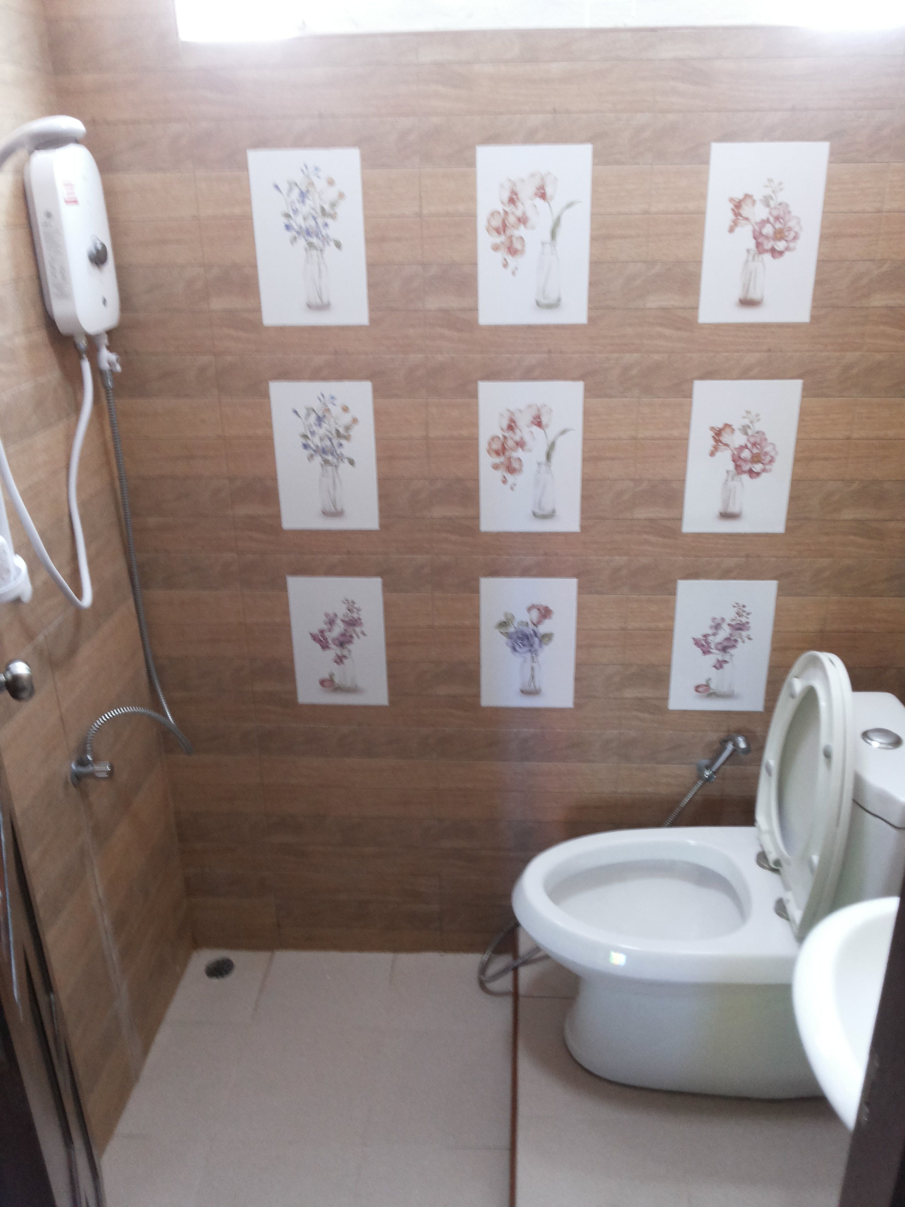 Un baño pequeño con inodoro, ducha y secador de manos instalado en la pared.