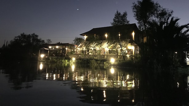 A waterfront property with a large house, a dock, and a reflection in the water. - River Jam Amphawa (Amphawa)