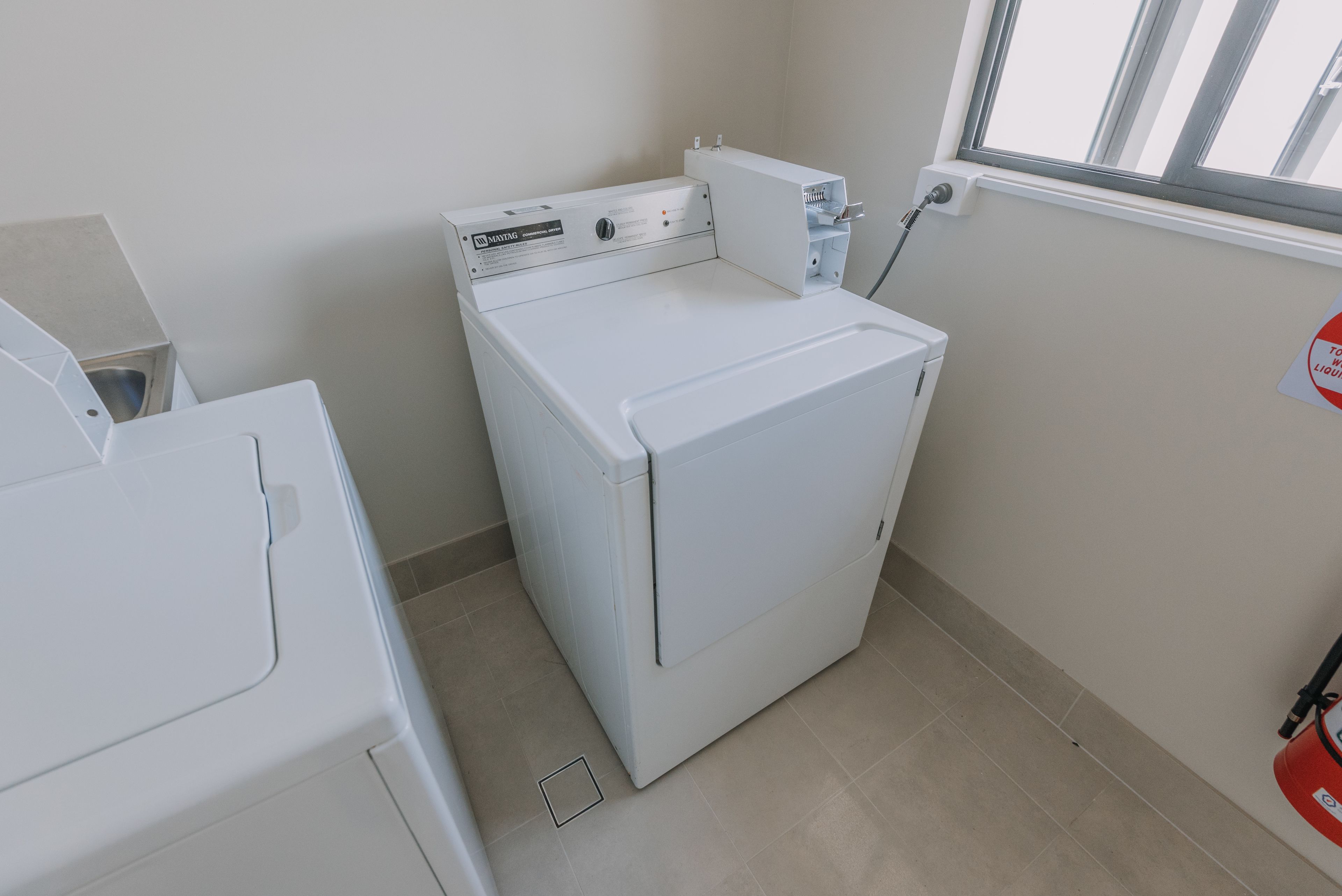 Une buanderie équipée d’un lave-linge à chargement frontal et d’un sèche-linge.