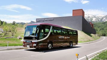 A bus with "LOTTE ARAI RESORT" written on it, parked on a road with a building in the background.
