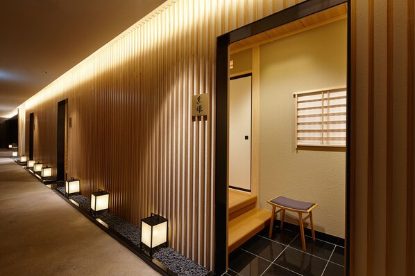 A hotel corridor with wooden paneling, a reception desk, and a seating area. - Lotte Arai Resort (Myoko)