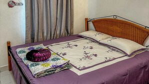 A bedroom with a bed, curtains, an air conditioning unit, a wall-mounted light, and a thermostat. - Lyaa Resthouse (Langkawi)