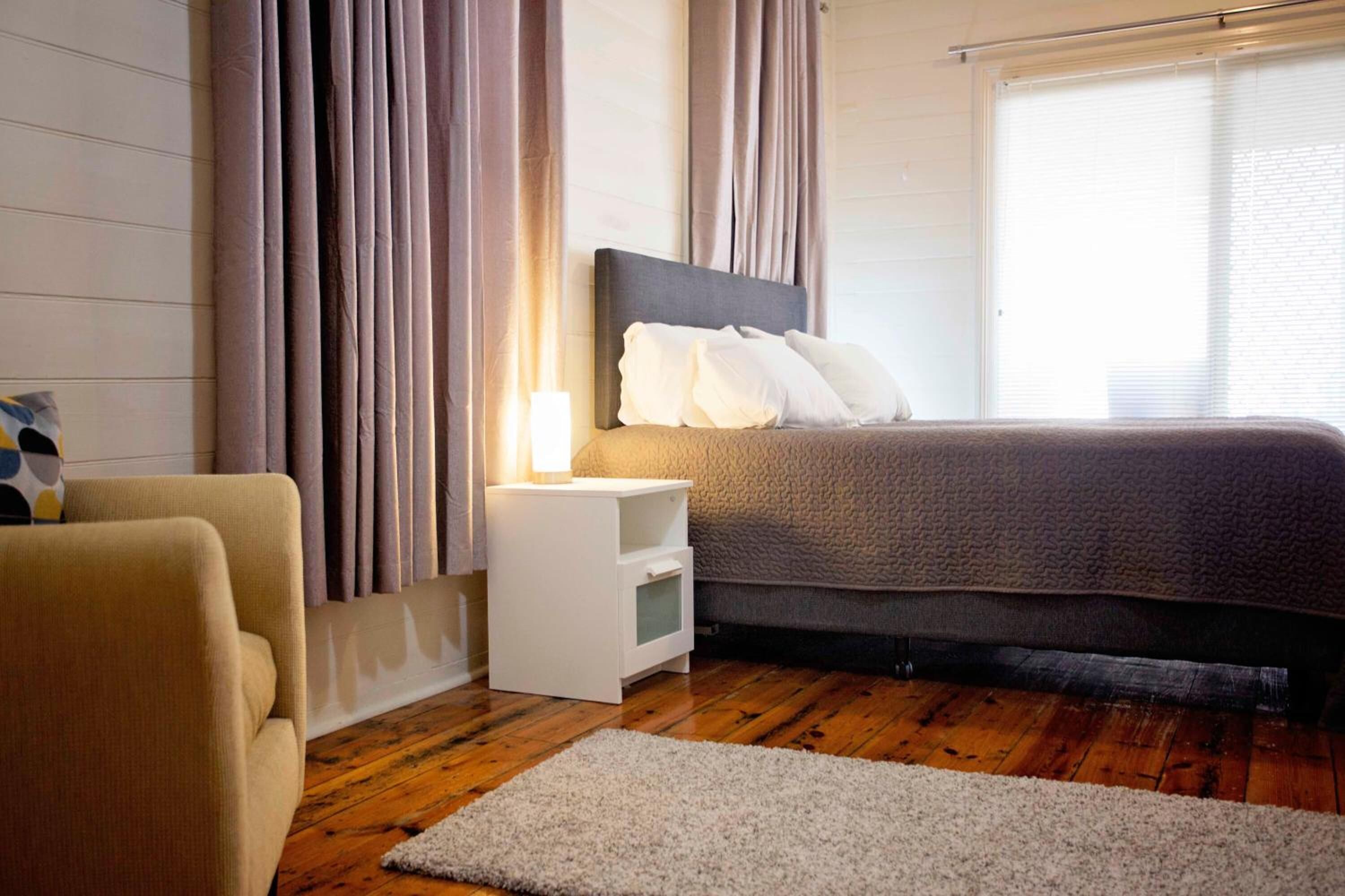 Une chambre à coucher avec un lit, une table de chevet et une chaise.
