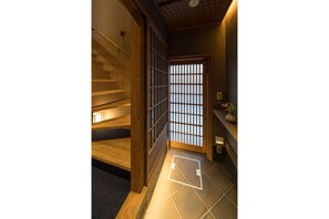 A wooden staircase with a traditional Japanese sliding door at the top. - Bonbori an (Kyoto)