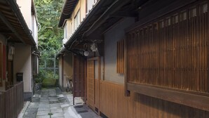 A narrow alleyway with traditional wooden buildings, stone paving, and a bicycle.