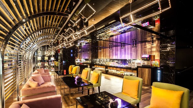 A modern bar area with seating and a bar counter.