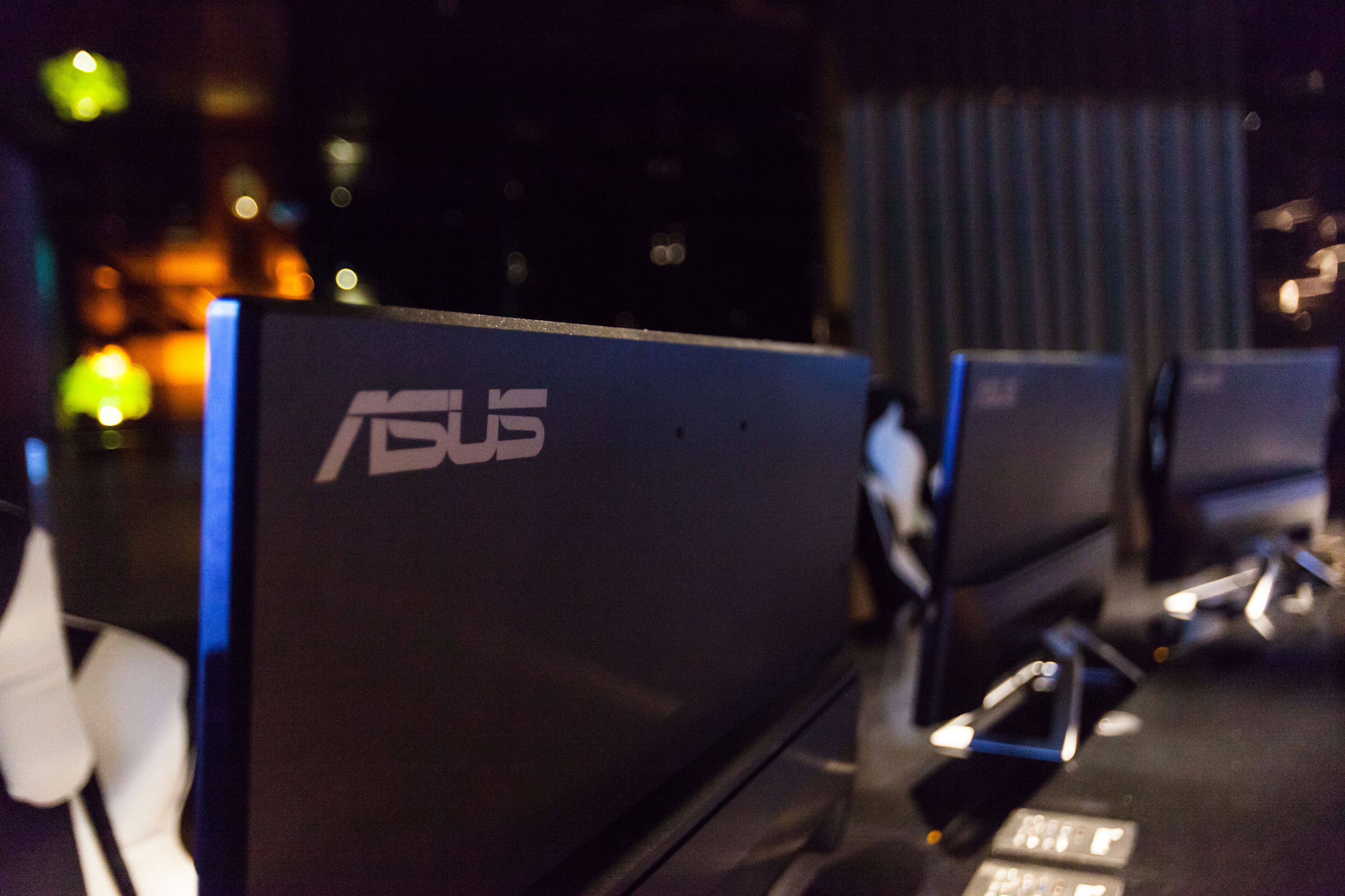 A row of ASUS branded computer monitors on display.