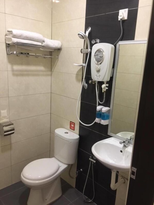 Un baño moderno con inodoro, lavamanos y cabina de ducha.