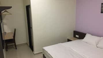 Habitación de hotel con cama, una silla, una mesita de noche y aire acondicionado instalado en la pared.