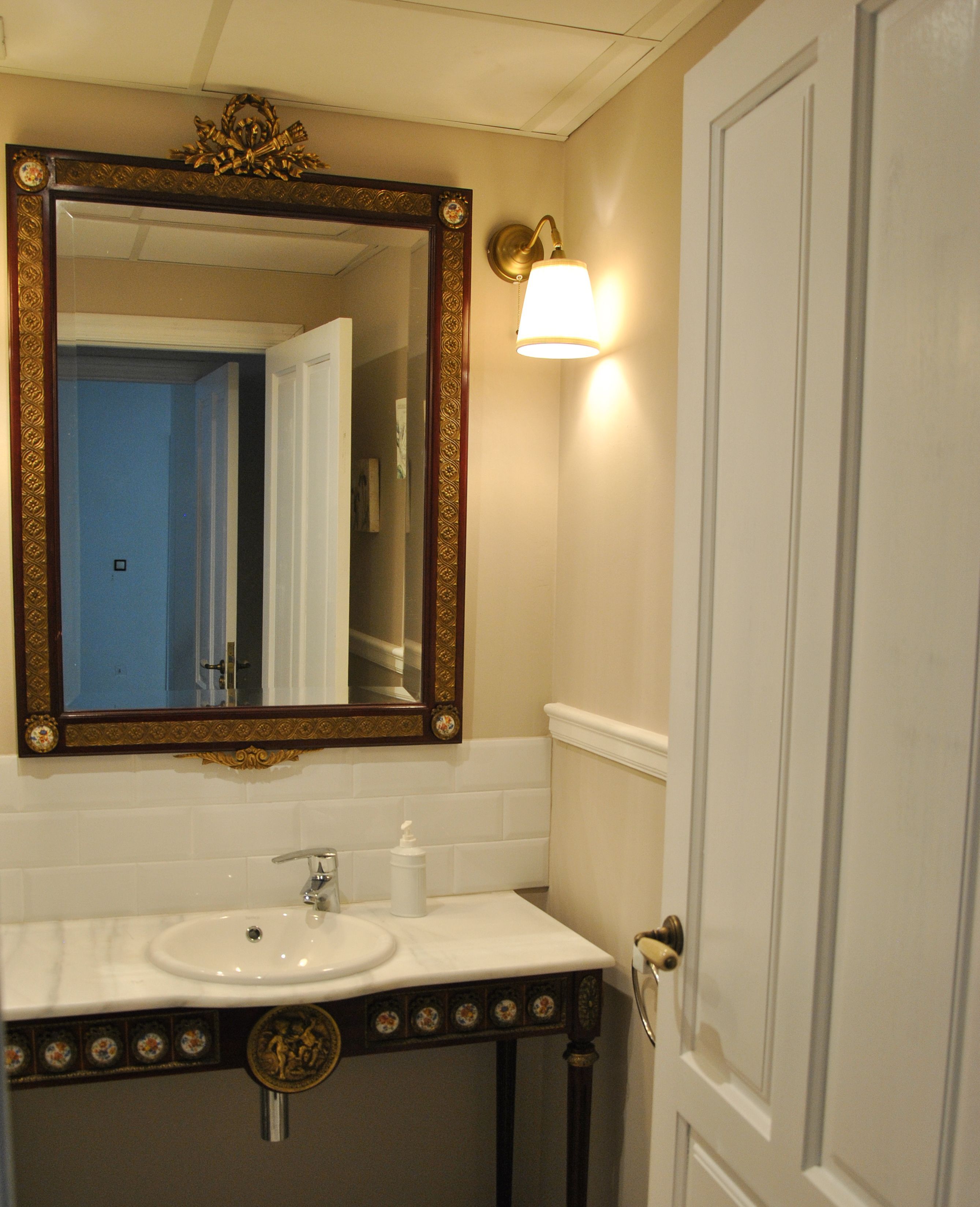 A bathroom with a large mirror, a sink, and a door.