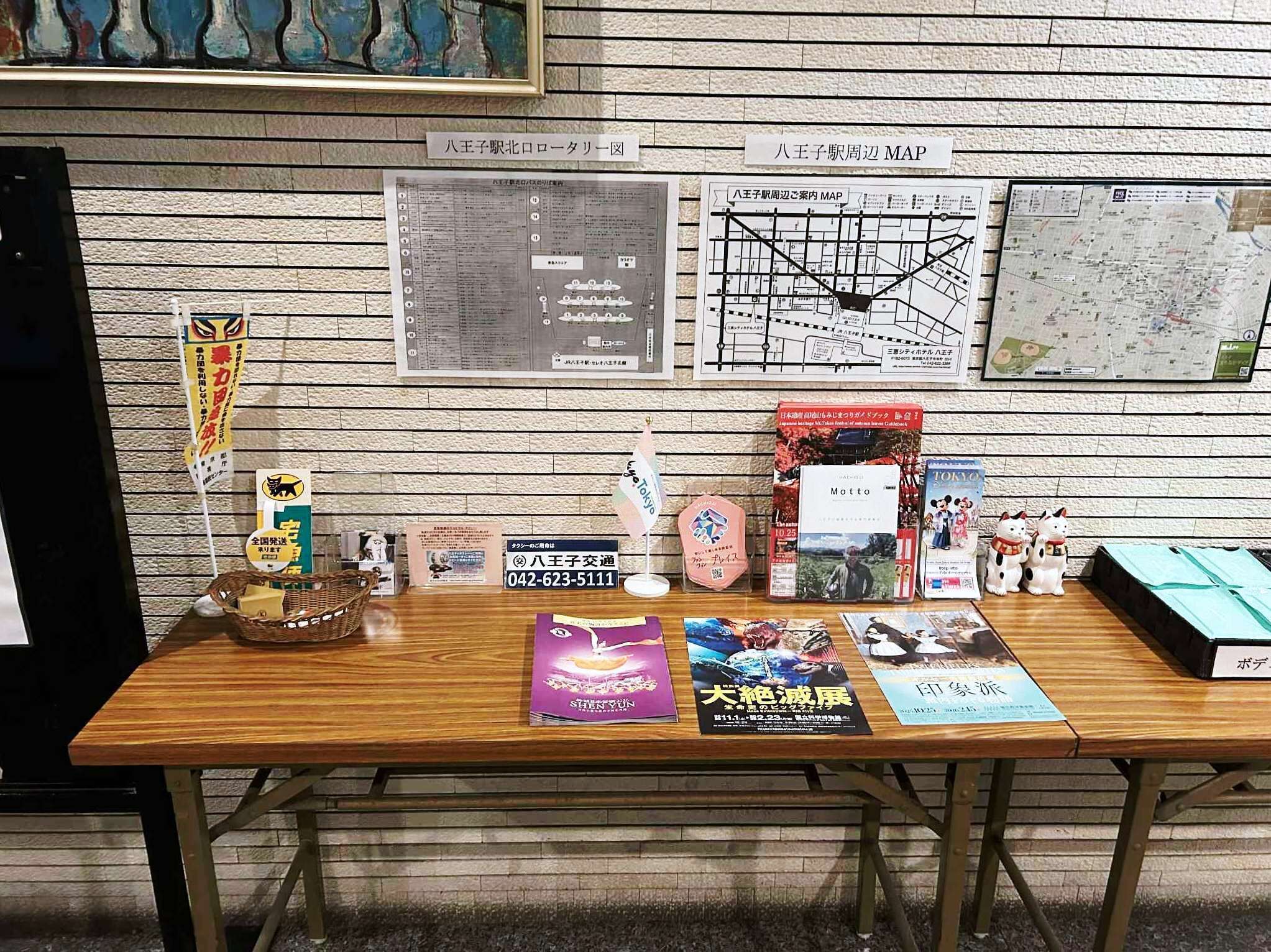 A wooden table with various items including a map, a book titled 'Motto', and a sign with contact information.