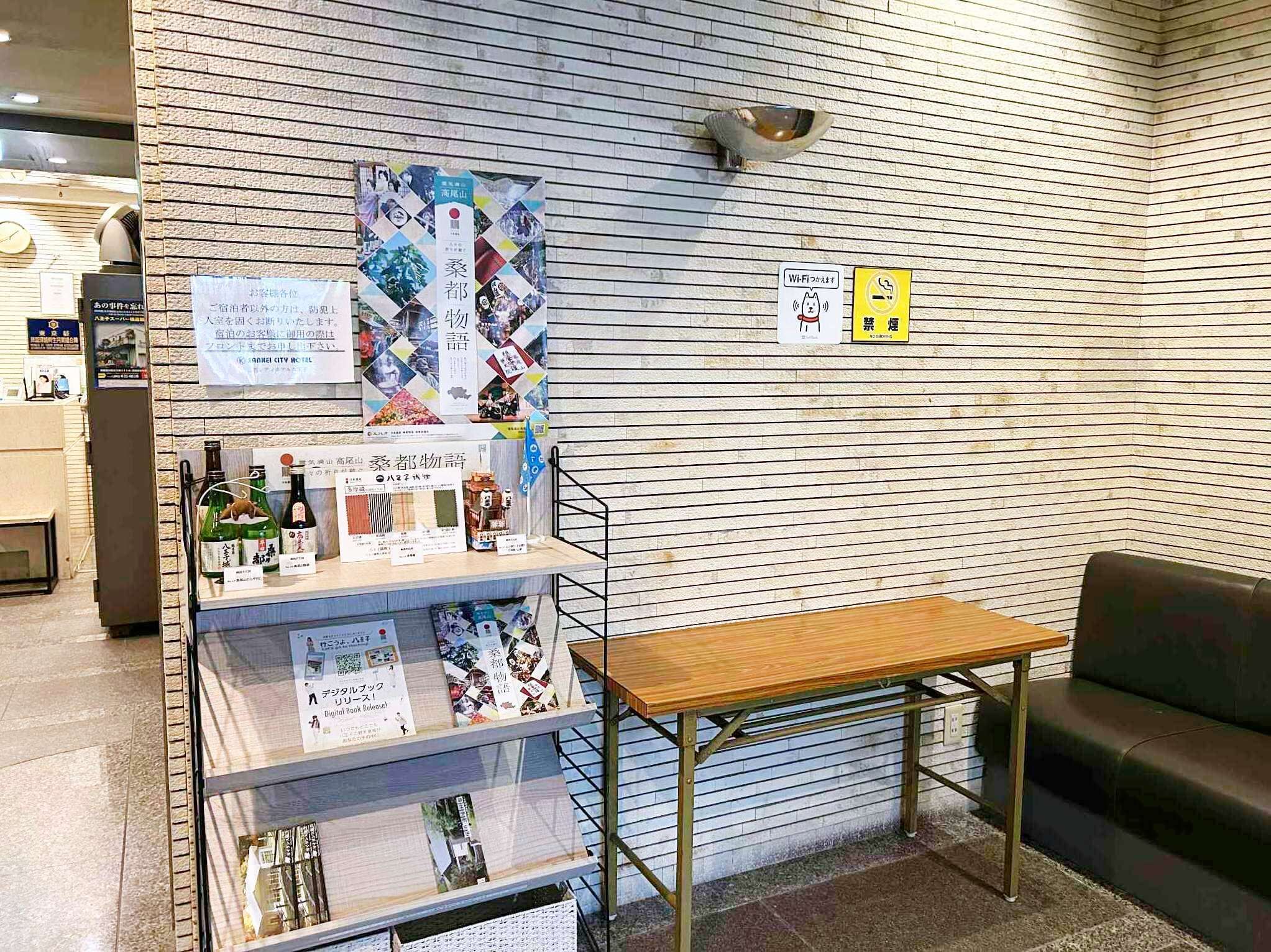 A reception area with a wooden table, a sofa, and a display of books and magazines.