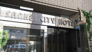 The exterior of the SANKEL CITY HOTEL with a clear view of the entrance and the name displayed above the doors. - Sankei City Hotel Hachiouji (Hachioji)