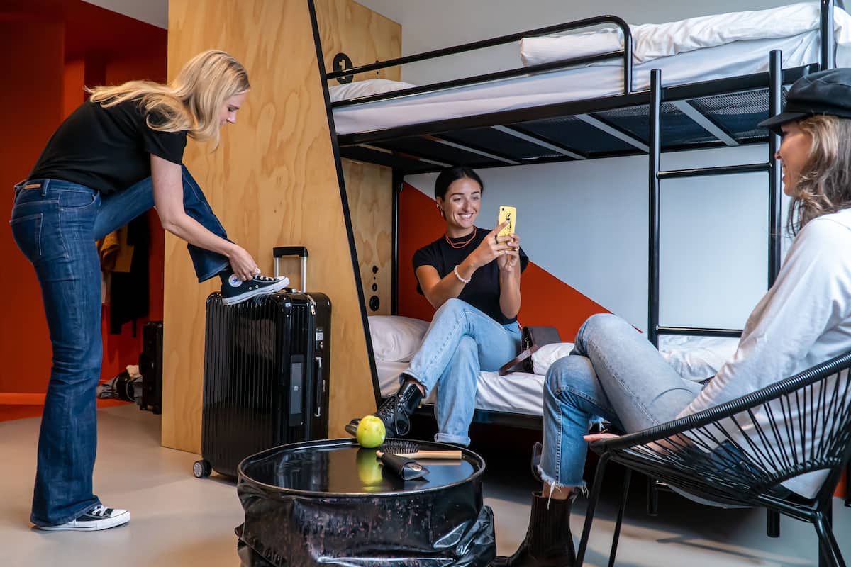 A bunk bed room with a suitcase, a bowl, and a brush on the floor.