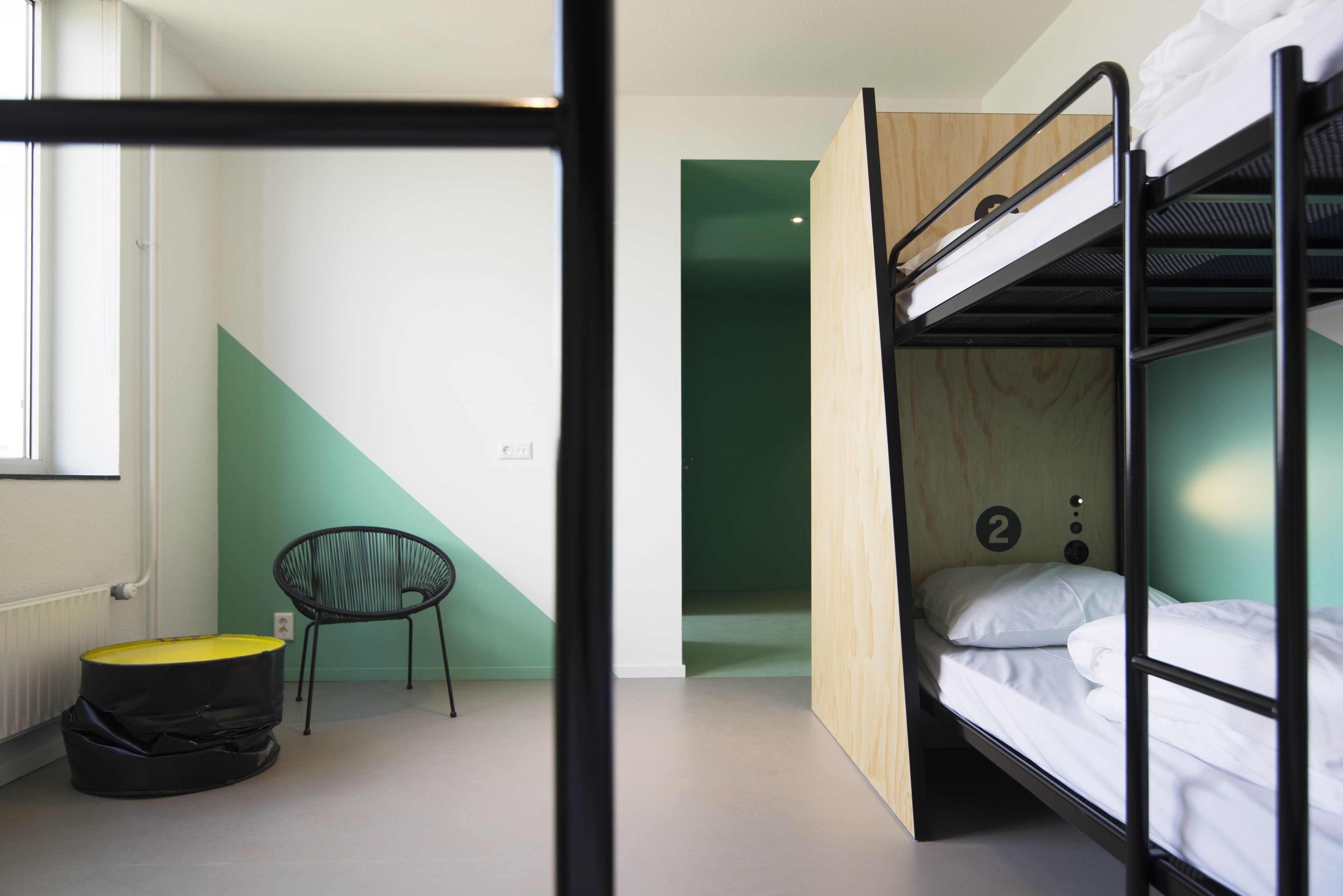 Una habitación con literas, una silla y una mesita.