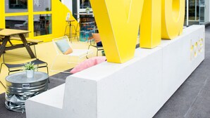 A modern building with large yellow letters spelling "Viva" on the facade. - Via Amsterdam - Hostel (Diemen)