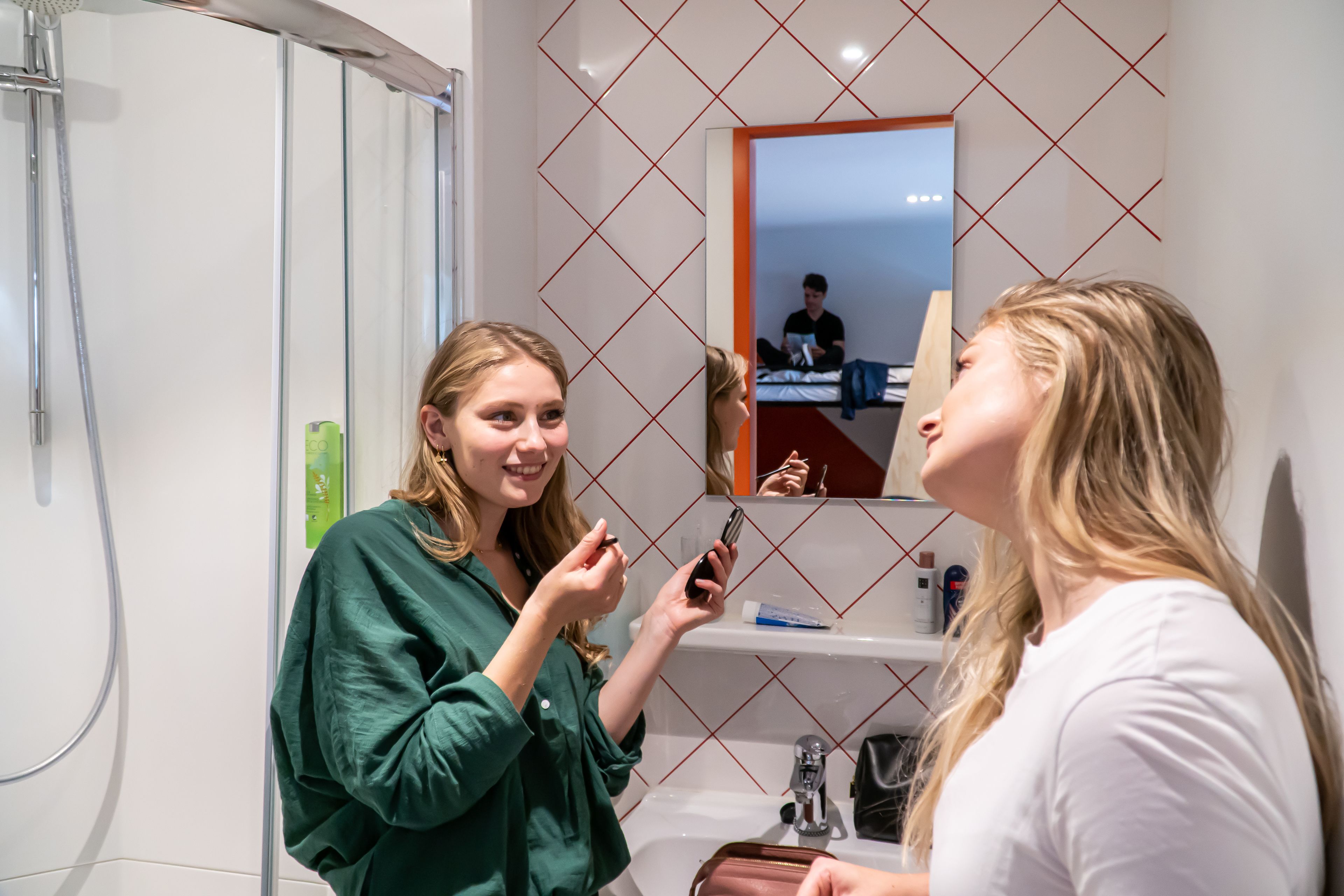 Un baño con espejo, lavamanos y ducha.