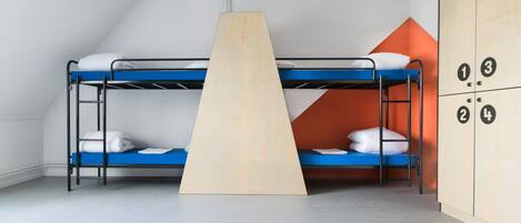 Un dormitorio con literas, una escalera de madera y un armario con compartimentos numerados.