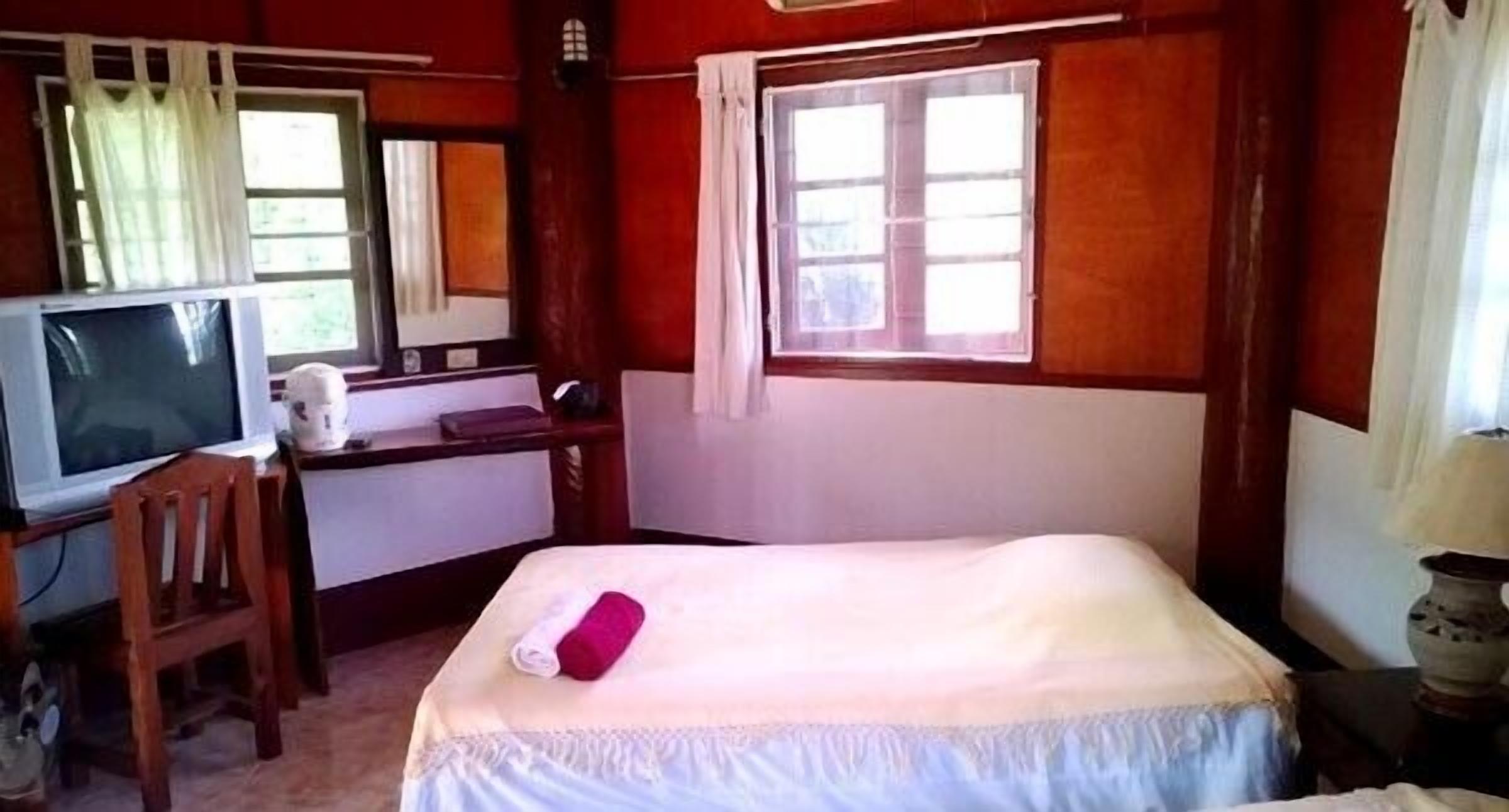 A room with a bed, a desk, a television, and a window.
