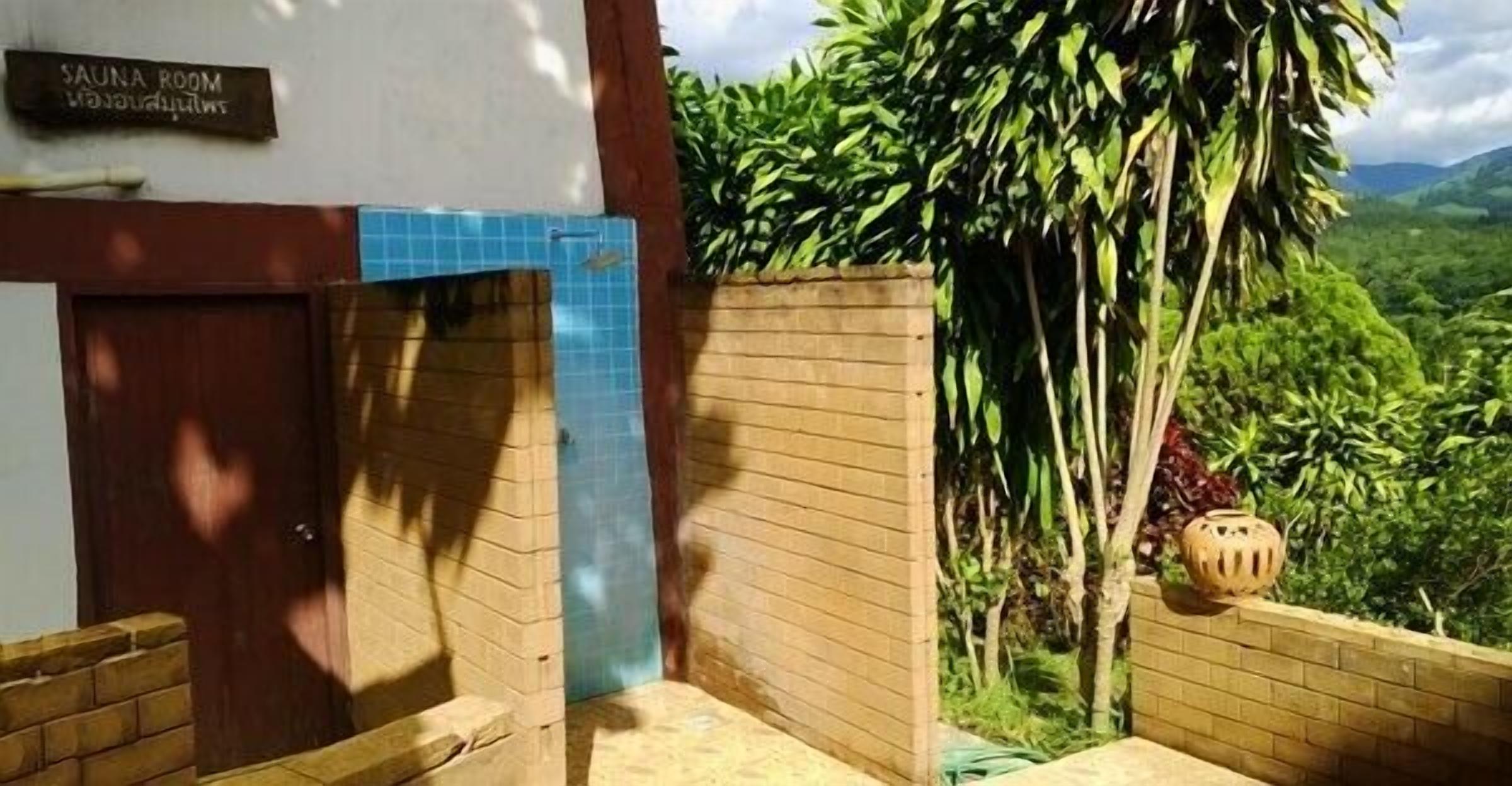 Un cuarto de spa con un letrero, una puerta y vistas de vegetación exuberante.