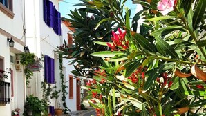 A cobblestone street lined with buildings, some with balconies and potted plants. - Amaranda Ada Evi - Adults Only (Bozcaada)