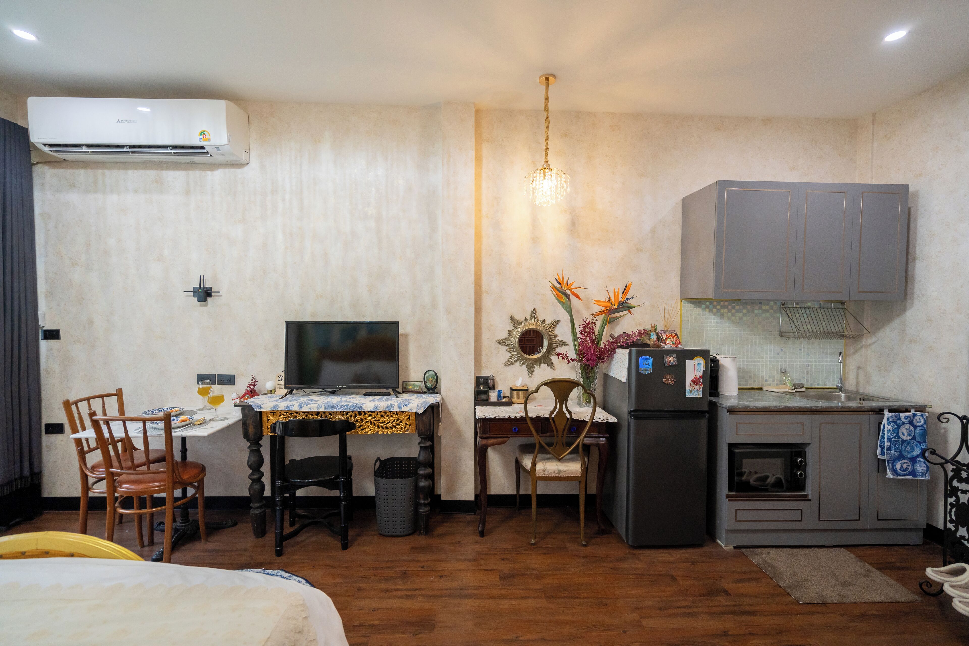 A compact kitchen with a refrigerator, oven, and a small dining area with chairs and a table.