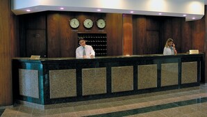 A reception desk with clocks displaying London, Berlin, and Ankara times, and a sign for a reservation desk. - Ozkaymak Park Hotel (Konya)