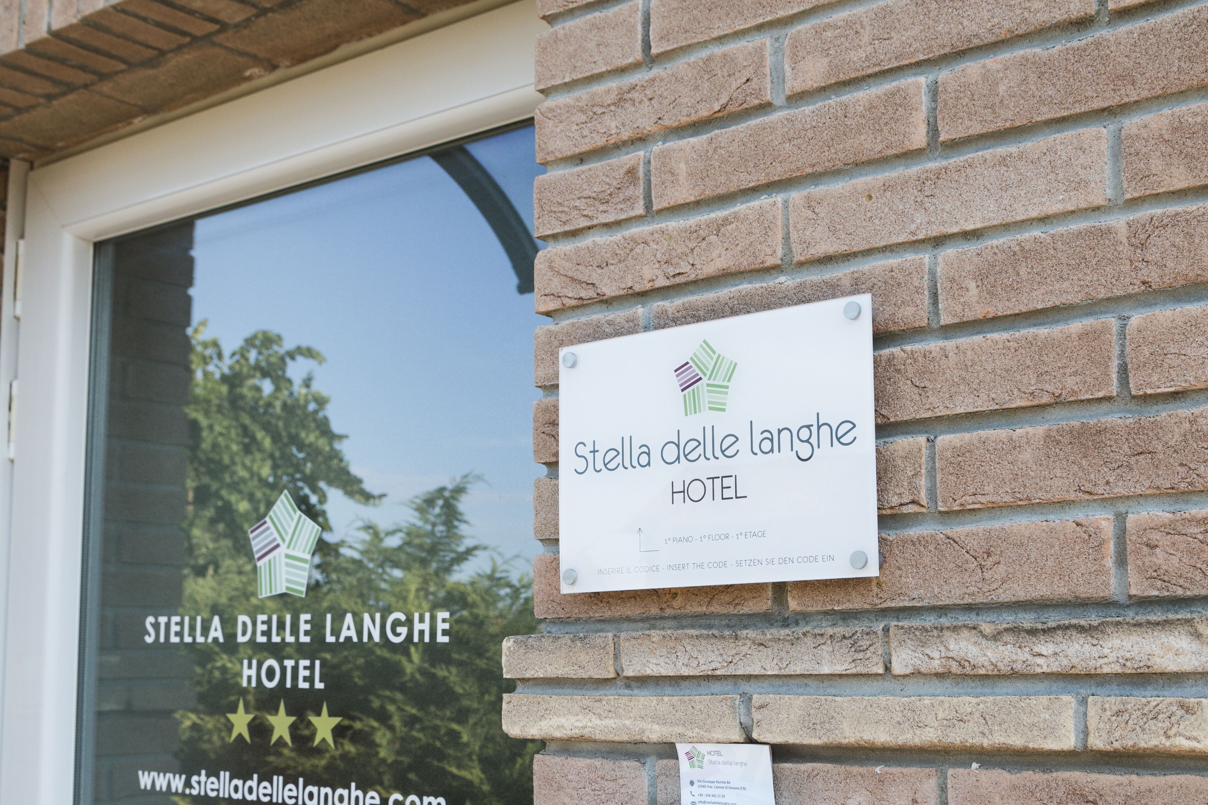 A hotel sign with the name "Stella delle Langhe HOTEL" and a website URL.