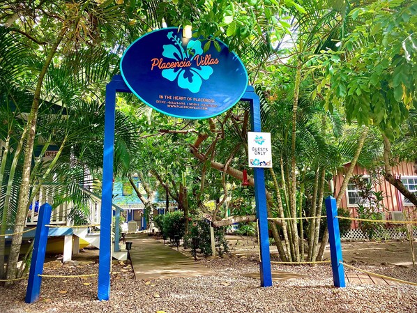 Señal de Placencia Villas con información de contacto y un letrero que dice 'Solo Huéspedes'.