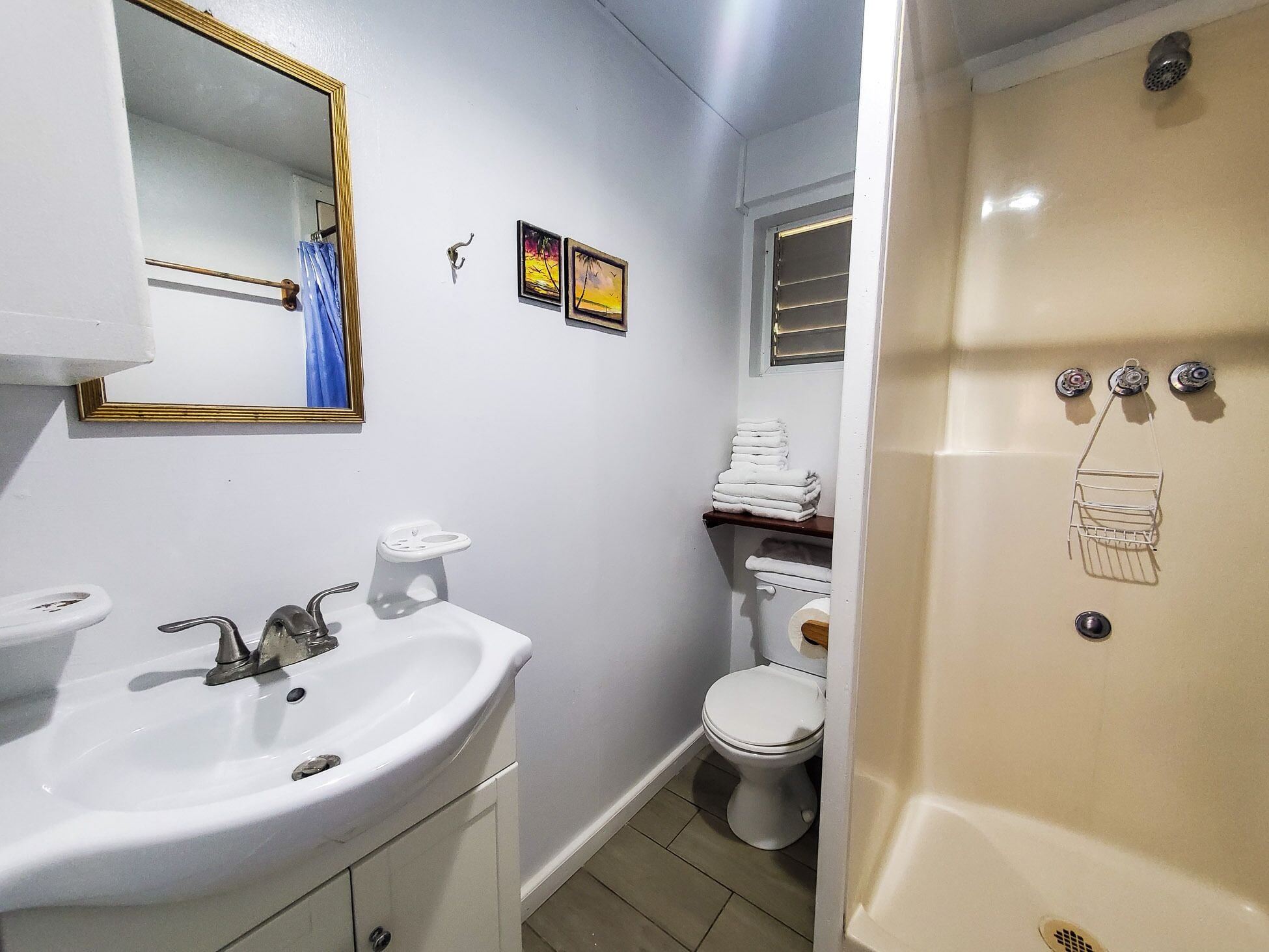 Ein Badezimmer mit Waschbecken, Spiegel, Toilette und Dusche.