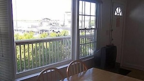 A room with a large window, a table, and chairs.
