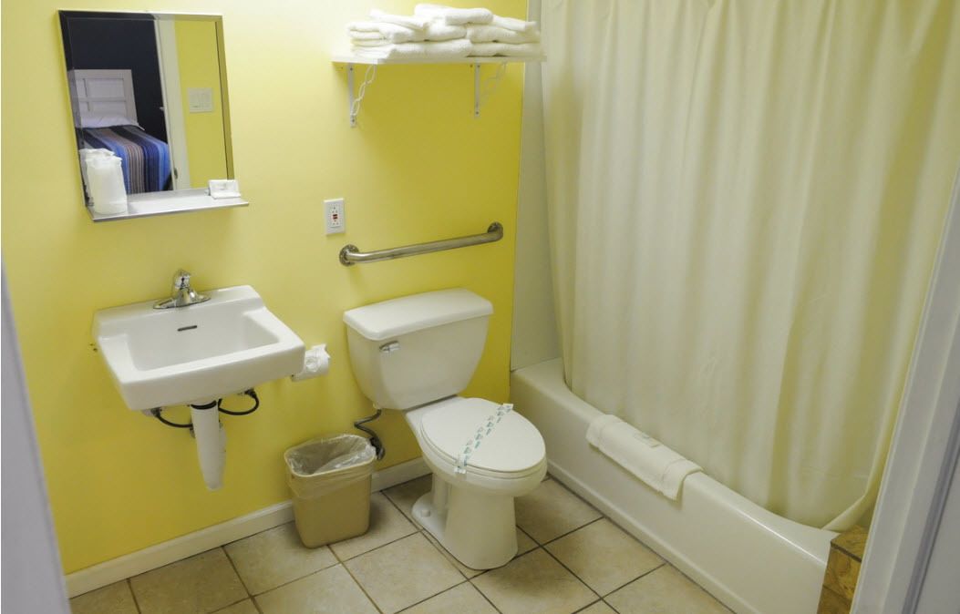 Un baño pequeño con lavamanos, inodoro y cortina de ducha.