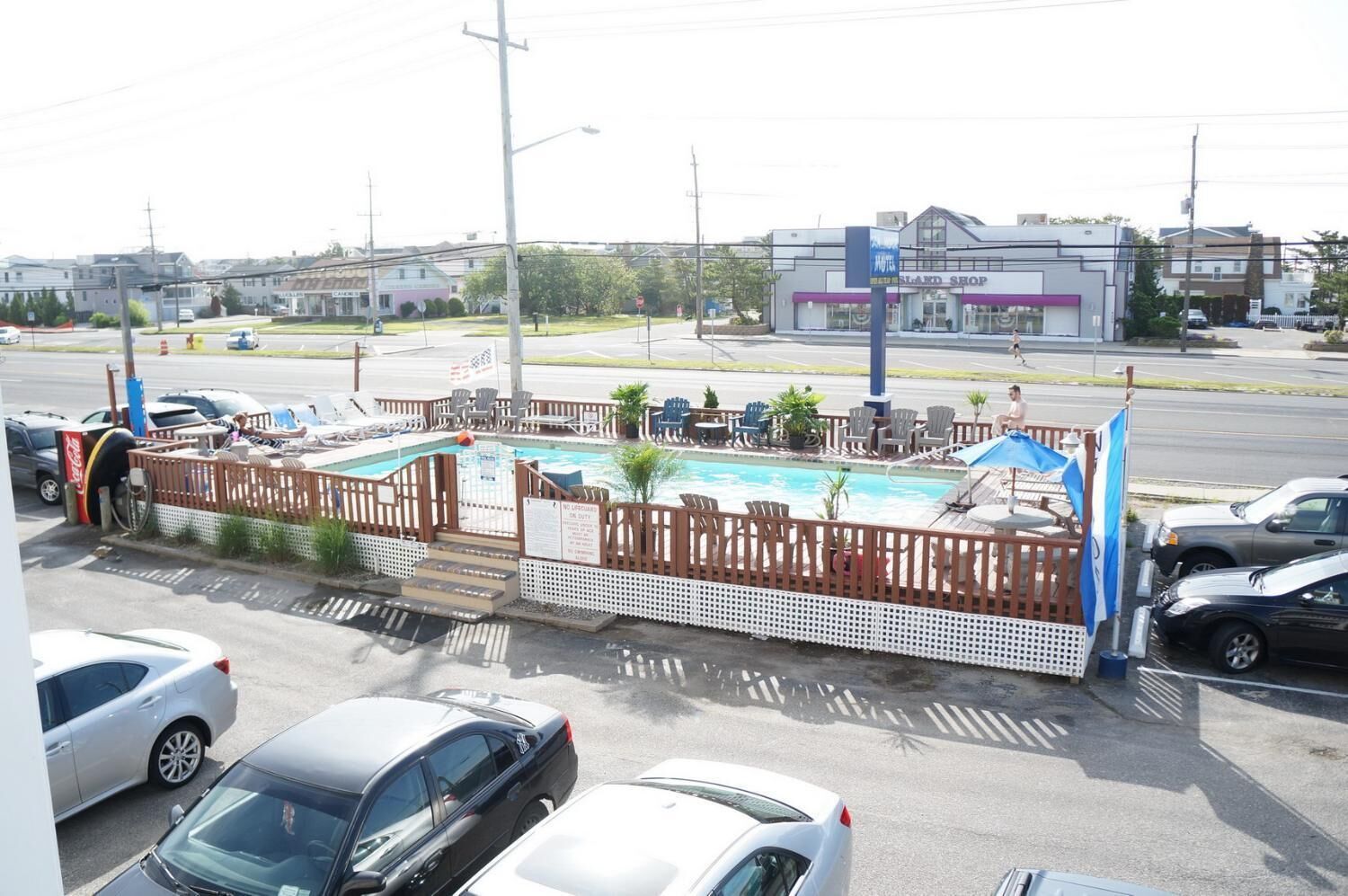 Un hôtel doté d’une piscine, d’un espace extérieur aménagé et d’une façade visible depuis la rue.
