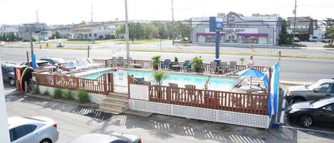 Un hôtel doté d’une piscine, d’un espace extérieur aménagé et d’une façade visible depuis la rue.