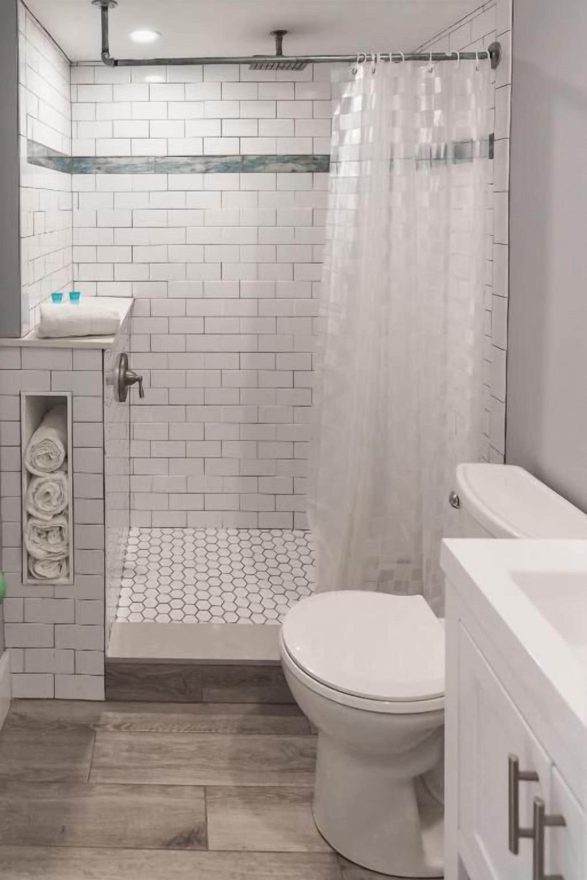 Een badkamer met douche, toilet en wastafel.