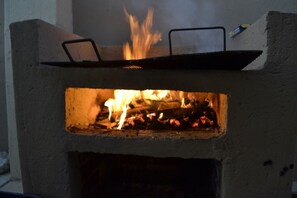A concrete outdoor grill with a fire burning inside. - Thembisi Guesthouse (Newcastle)