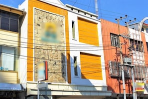 A multi-story building with a mix of architectural styles, including a section with a stone facade and large windows.