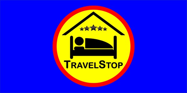 A logo with a bed icon and the text "TravelStop" inside a yellow circle with a red border. - TravelStop #London-Ealing (London)