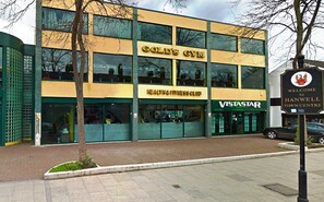 A multi-story building with a sign for 'Gold's Gym' and 'Health & Fitness Club'. - TravelStop #London-Ealing (London)
