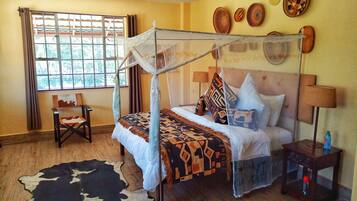 Quarto com uma cama, uma cadeira, uma janela e uma parede decorada com pratos.