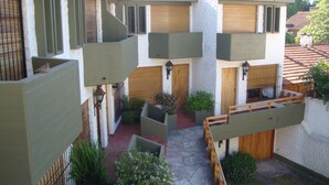 A multi-level courtyard with balconies, stone flooring, and potted plants. - Triplex Nro 2 Costa Atlantica Argentina (San Bernardo del Tuyú)