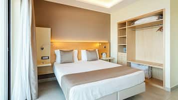 Une chambre d’hôtel avec un grand lit, des tables de chevet, une armoire et une petite table de nuit.