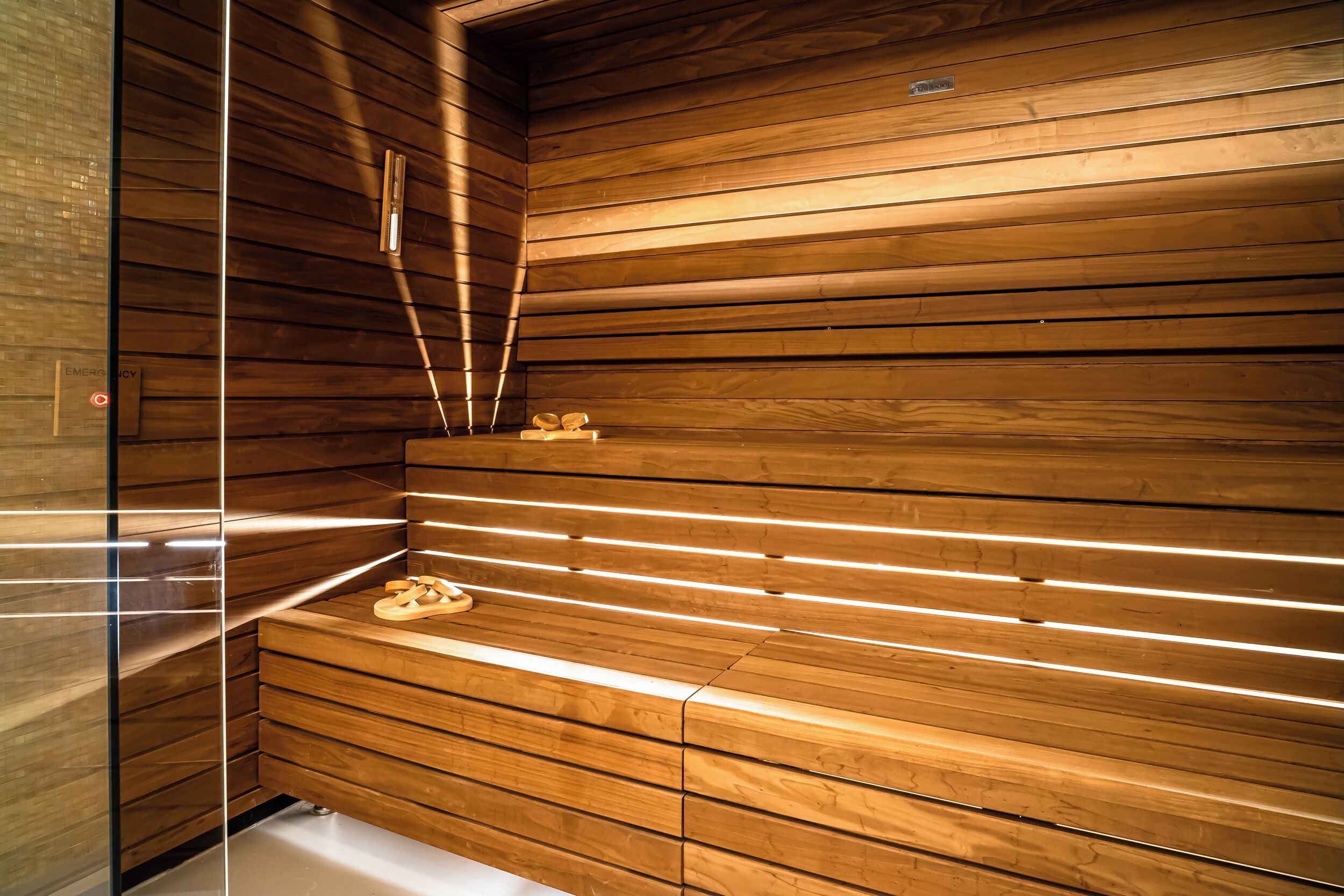 A sauna with wooden slats and a bench.