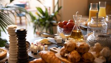A breakfast buffet with various cheeses, breads, and pastries.